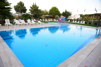 a large swimming pool with chairs and a water slide at Rose Hotel Faliraki in Faliraki