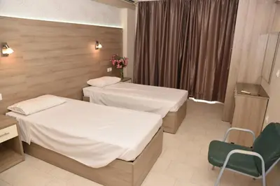 a hotel room with two beds and a window at Rose Hotel Faliraki in Faliraki