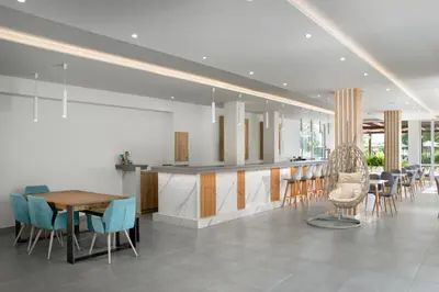 a kitchen and dining room with a table and chairs at Rose Hotel Faliraki in Faliraki