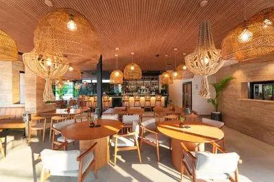 a restaurant with wooden tables and chairs and chandeliers at Hippocampus Boutique Hotel in Ixia
