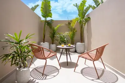 a patio with chairs and a table and plants at Hippocampus Boutique Hotel in Ixia