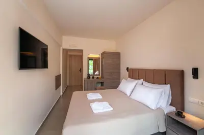 a bedroom with a large bed with two towels on it at Hippocampus Boutique Hotel in Ixia