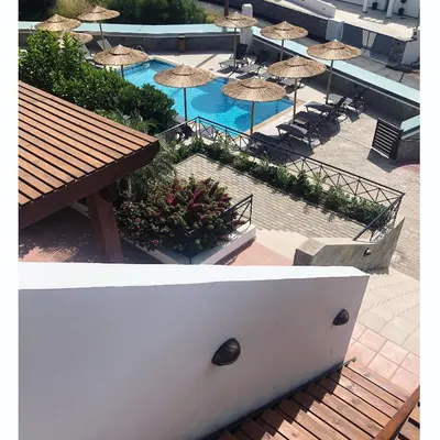 two pictures of a pool with umbrellas and tables and chairs at Southern Dreams Apartments in Gennadi