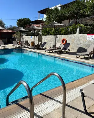 a large swimming pool with chairs and umbrellas at Southern Dreams Apartments in Gennadi