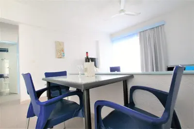 a table with blue chairs and a bottle of wine at Christiana Hotel Apartments in Gennadi