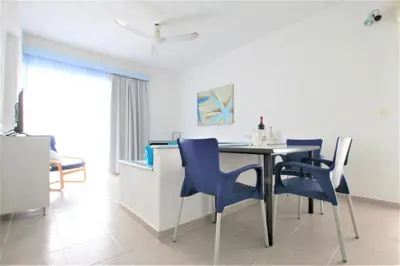 a dining room with blue chairs and a table at Christiana Hotel Apartments in Gennadi