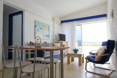 a living room with a dining room table and chairs at Christiana Hotel Apartments in Gennadi