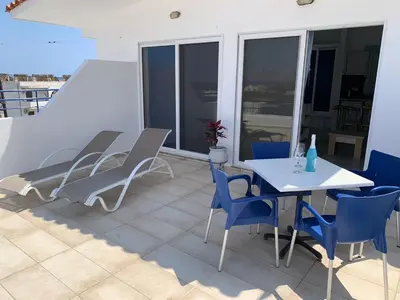 a patio with a table and chairs on a balcony at Christiana Hotel Apartments in Gennadi
