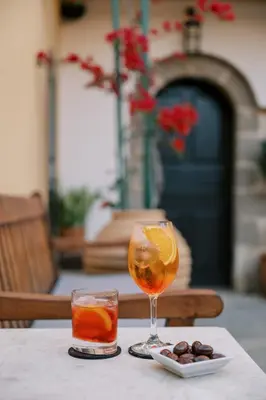 a table with a glass of orange juice and a drink at Zacosta Villa - a Heritage Hotel in Rhodes Town