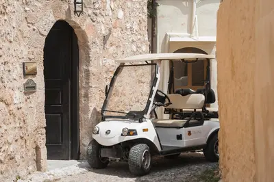 a white golf cart parked next to a building at Zacosta Villa - a Heritage Hotel in Rhodes Town