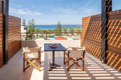 a balcony with a table and chairs and the ocean at D'Andrea Mare Hotel in Ialyssos