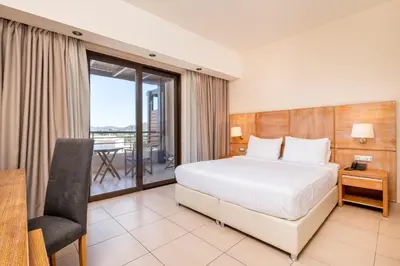 a hotel room with a bed and a balcony at D'Andrea Mare Hotel in Ialyssos