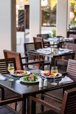 a table with plates of food and glasses of wine at D'Andrea Mare Hotel in Ialyssos
