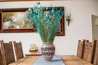 a vase with grass in it sitting on a table at Anna's House Traditional in Halki