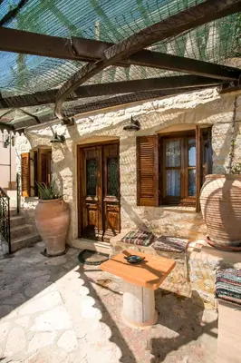 a patio with a wooden table in front of a building at Anna's House Traditional in Halki