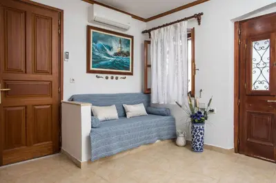 a living room with a blue couch in front of a door at Anna's House Traditional in Halki