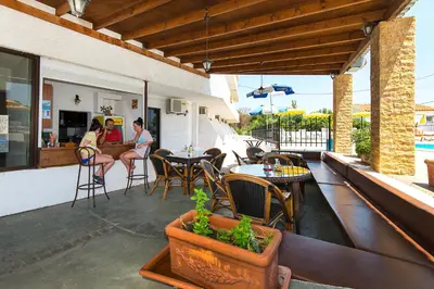 two women sitting at a bar on a patio at Butterfly Studios, Faliraki in Faliraki