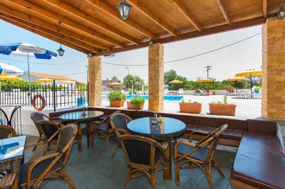 a patio with tables and chairs and a pool at Butterfly Studios, Faliraki in Faliraki