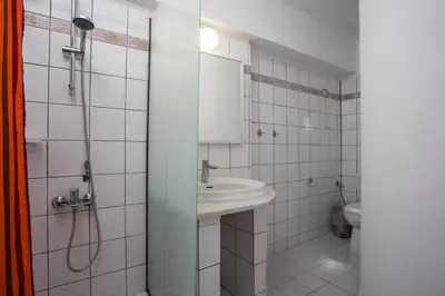 a bathroom with a sink and a shower and a toilet at Sabrina Studios in Faliraki