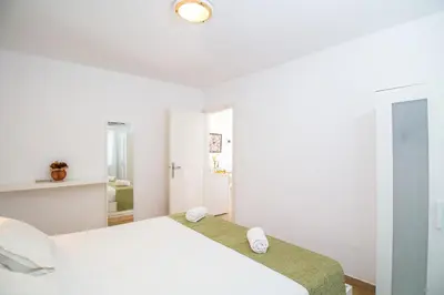 a white bedroom with a bed and a mirror at Sabrina Studios in Faliraki