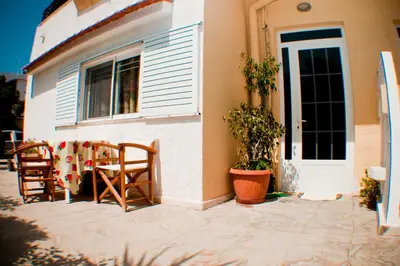 a patio with two chairs and a table in front of a house at Sabrina Studios in Faliraki