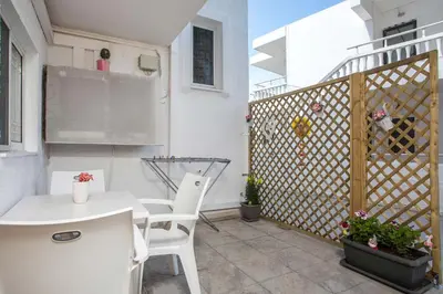 a patio with a white table and chairs and a fence at Sabrina Studios in Faliraki