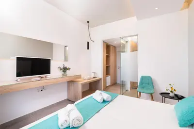 a hotel room with a bed and a tv at Happy Days Hotel, Adults Only in Theologos