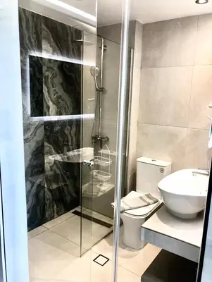 a bathroom with a shower and a toilet and a sink at Happy Days Hotel, Adults Only in Theologos