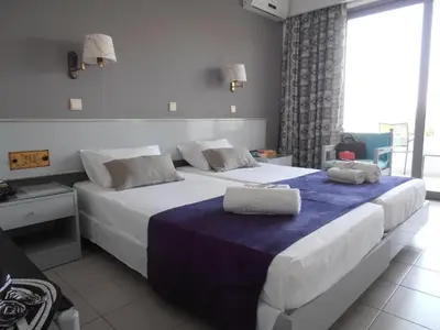 a hotel room with two beds with towels on them at Happy Days Hotel, Adults Only in Theologos
