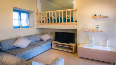 a living room with a couch and a flat screen tv at Amazing House in Halki in Halki