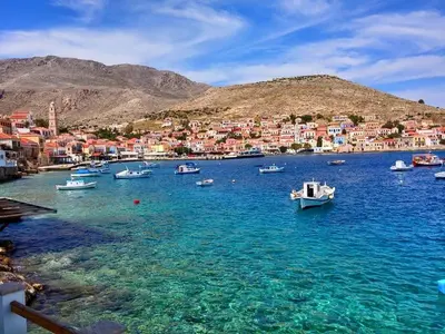 a group of boats in a body of water with houses at Amazing House in Halki in Halki