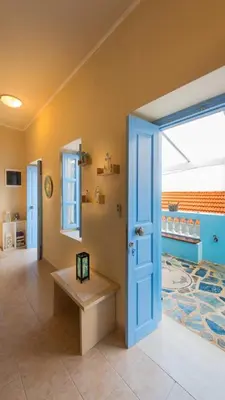 a room with a blue door and a bench at Amazing House in Halki in Halki