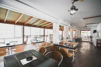 a living room with tables and chairs and windows at Coliseum Studios & Apartments in Pefki Rhodes