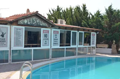 a hotel with a swimming pool in front of a building at Coliseum Studios & Apartments in Pefki Rhodes