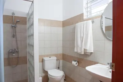 a bathroom with a toilet and a sink and a mirror at Coliseum Studios & Apartments in Pefki Rhodes
