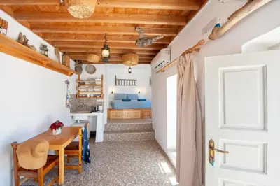 a kitchen and dining room with a table and a bed at Lindos Marianthi Studios in Líndos