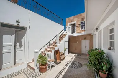 a balcony of a house with stairs and plants at Lindos Marianthi Studios in Líndos