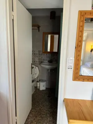 a bathroom with a sink and a toilet and a mirror at Lindos Marianthi Studios in Líndos