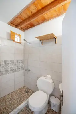 a white bathroom with a toilet and a sink at Lindos Marianthi Studios in Líndos