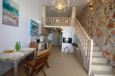 a kitchen and dining room with a staircase and a dining table at Kathara Bay Apartments in Faliraki