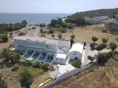 an aerial view of a white building with the ocean at Kathara Bay Apartments in Faliraki