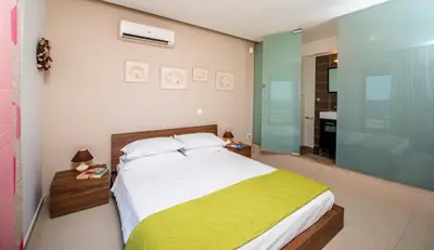 a bedroom with a large bed and a bathroom at Blue Wave Villa in Gennadi