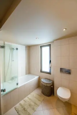 a bathroom with a tub and a toilet and a sink at Blue Wave Villa in Gennadi