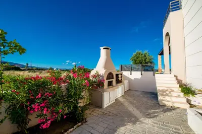 a house with a flower garden and a building at Blue Wave Villa in Gennadi