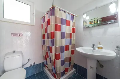 a bathroom with a sink and a toilet and a shower curtain at Anelia Boutique Studios & Apartments in Faliraki