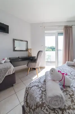 a bedroom with two beds and a desk with a mirror at Anelia Boutique Studios & Apartments in Faliraki
