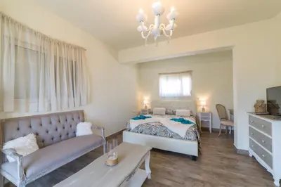 a bedroom with a bed and a couch and a table at Anelia Boutique Studios & Apartments in Faliraki