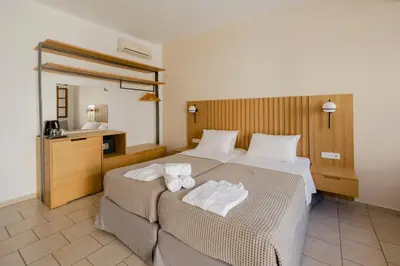 a hotel room with two beds and a mirror at Opera House Hotel in Symi