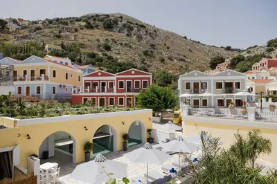 a view of a town with houses and umbrellas at Opera House Hotel in Symi