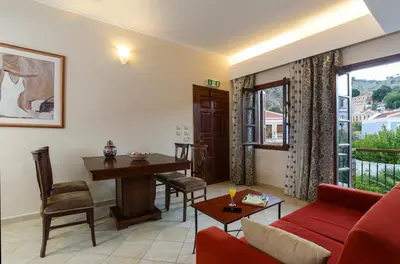 a living room with a red couch and a table at Opera House Hotel in Symi